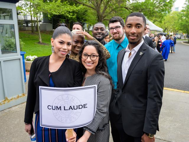 Cum Laude students pose behind their sign saying they are cum laude
