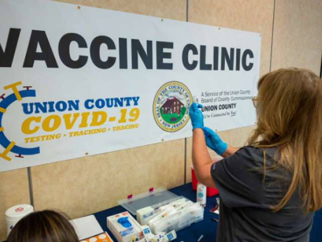 A nurse prepares a COVID-19 vaccine at the vaccination site on Kean University's campus.