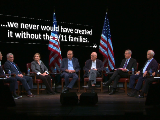 A group of people in a semicircle sit on stage. Overhead are the words, "we never would have created it without the 9/11 families."