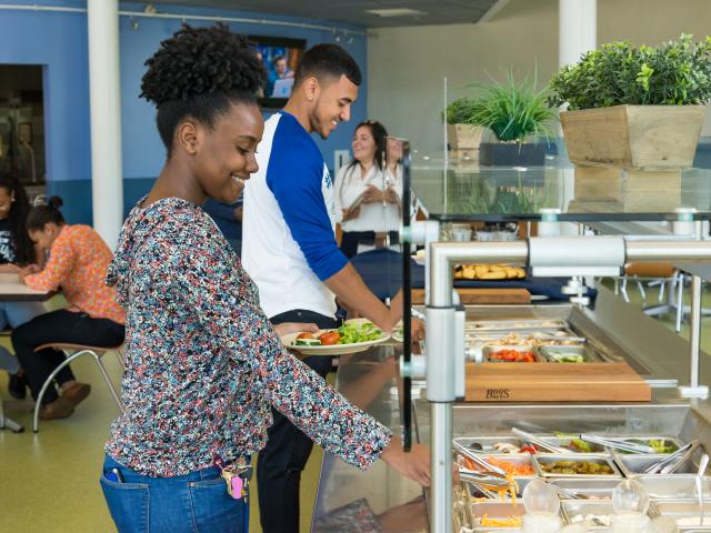 Kean University students serve themselves at the residence hall cafeteria salad bar
