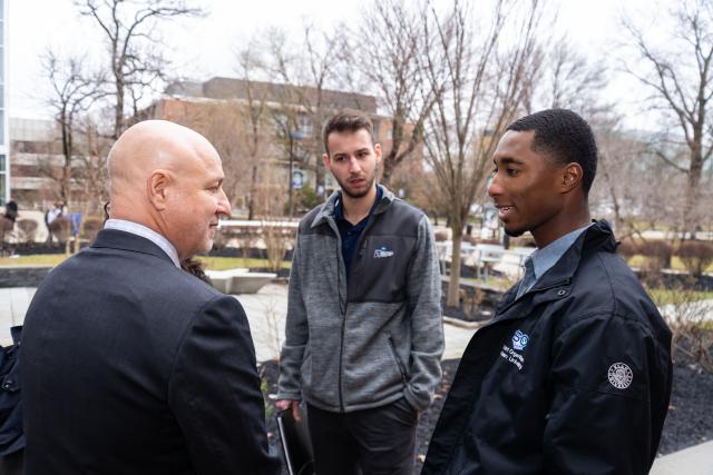 Chef Tom Colicchio talks with two Kean University students on the Union campus.