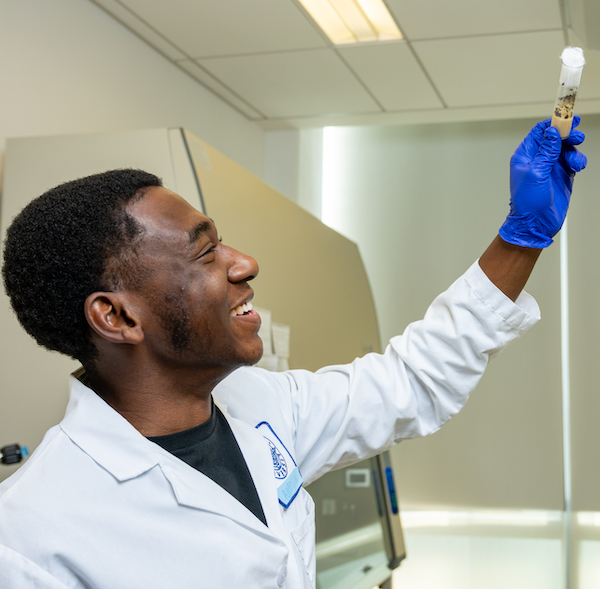 Kean student researcher holds test tube filled with insects