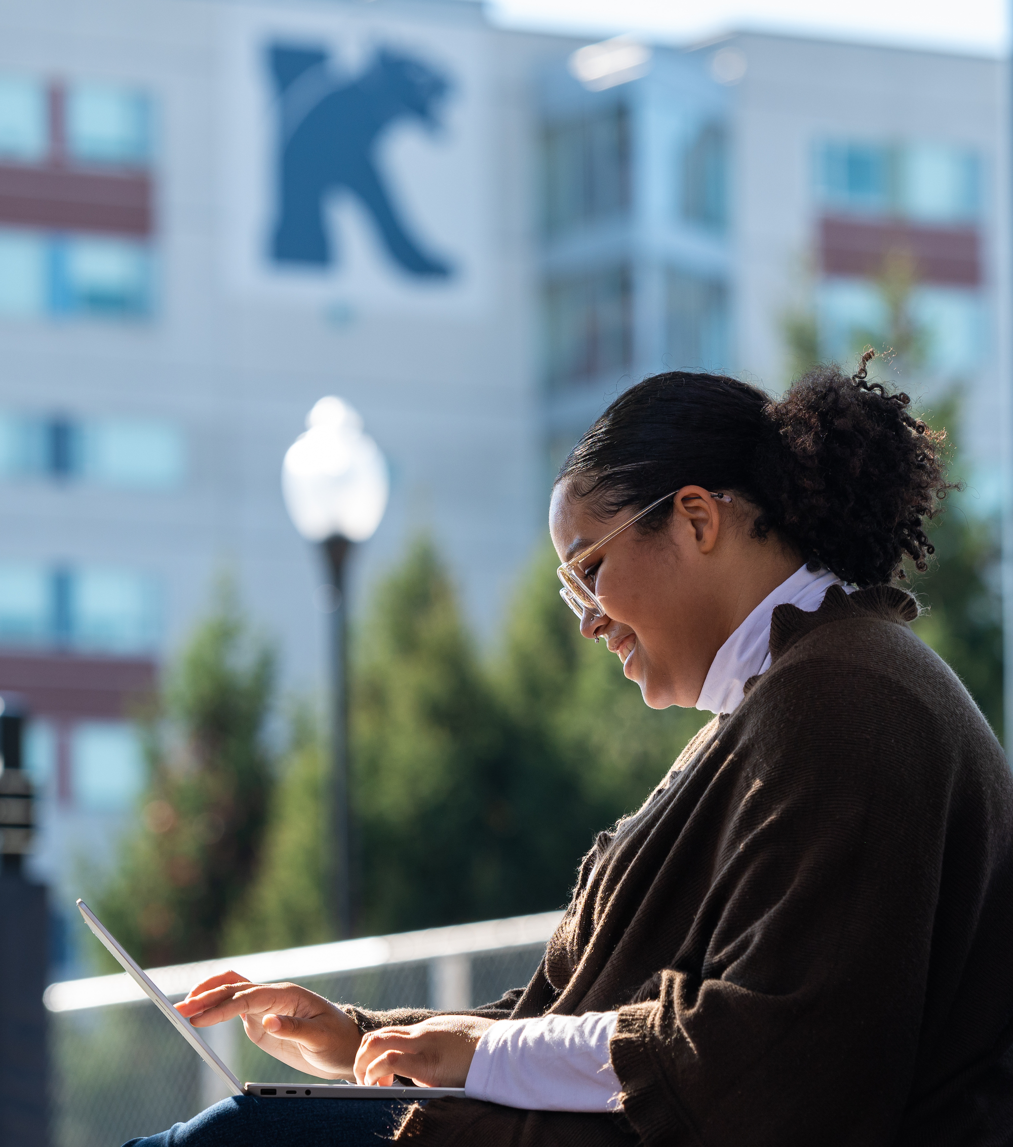 Kean student studies on a laptop outside of the quad. 