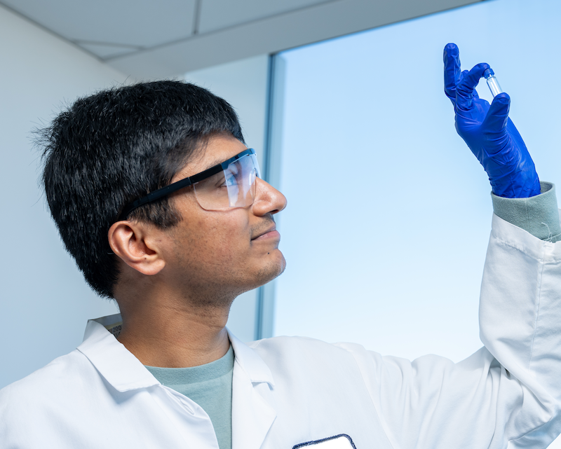 A student researcher holds up a recent drug discovery 