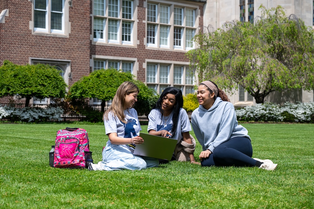 Kean Jersey City students recline on the lawn in front of Hepburn Hall 