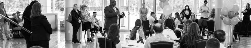 Dr. Repollet speaking into a microphone at the annual OT celebration of research and practice in the STEM building