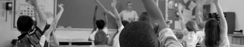 Students raise their hands in an urban classroom setting