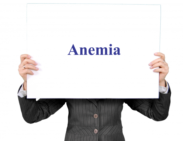 Person holding a sign that says "Anemia"