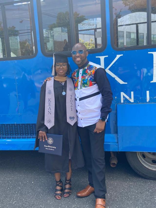Kean 2021 Grad Student with Distinction Jeminat Musa and her husband Edward pose in front of the Kean trolley.