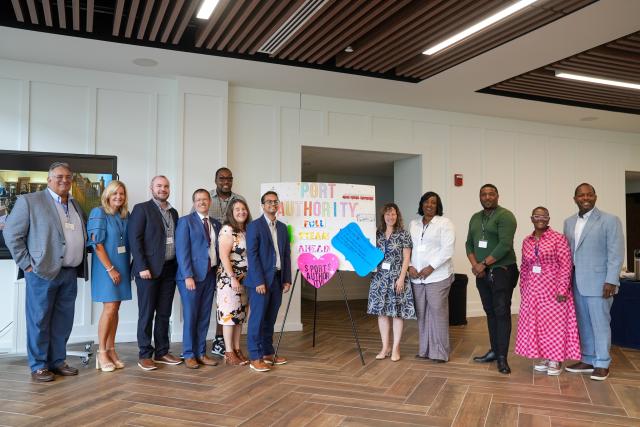 A group of officials pose at the closing event for Full STEaM Ahead summer program