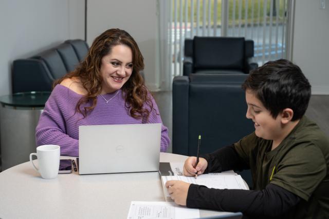 Kean Online Student studies at home with her son