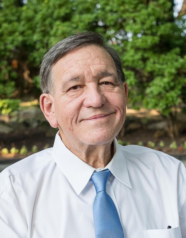 Gary Gerold wears a white shirt and tie in headshot picture
