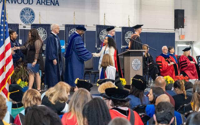 President Repollet shakes an honors graduate's hand at convocation