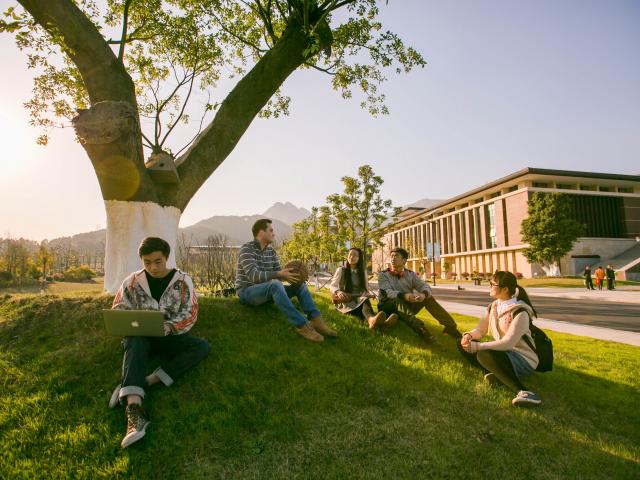Wenzhou-Kean University students talking on the grass.