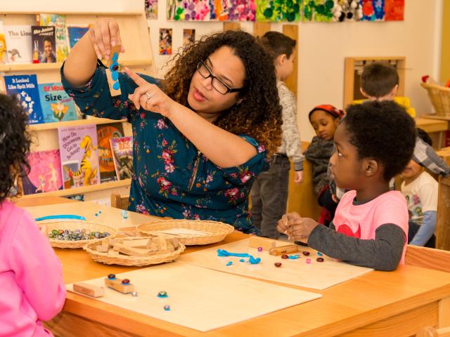 Kean student interacts with 2 children at Kean's Child Care Center