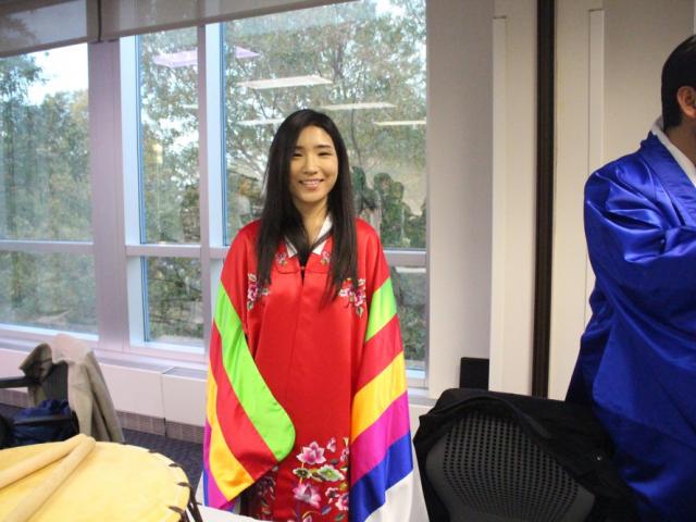 Student standing in colorful clothing smiling at camera