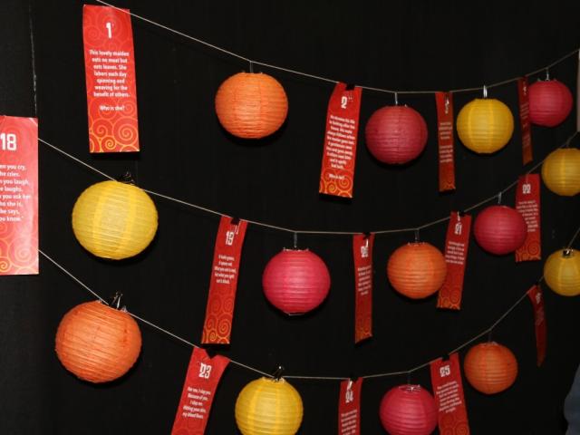Colorful photo of lanterns hanging on a line of rope at night