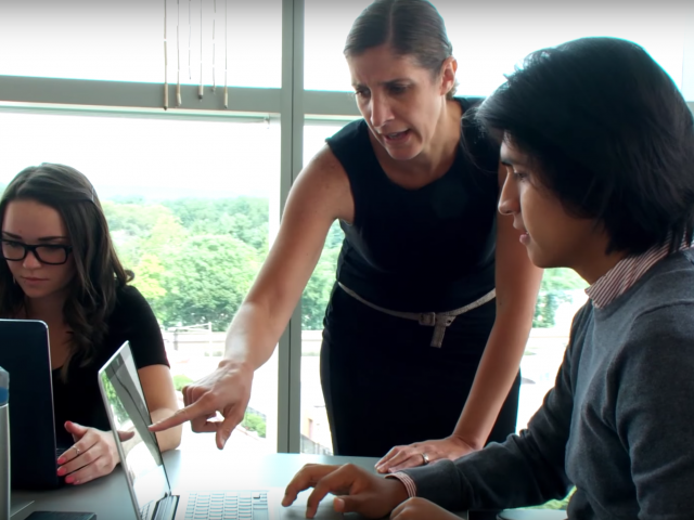 A professor works with Kean students on a K-Labs project.