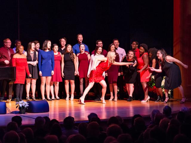 Kelli O'Hara leans over to share microphone with students to showcase their talents.