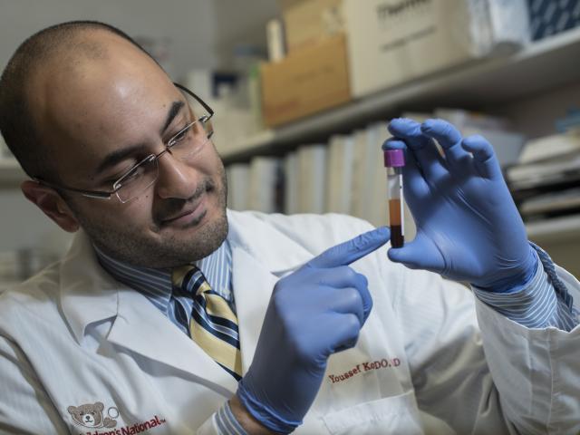 Dr. Yousseff Kousa ’05, ’07 M.S. examines a test tube in the lab