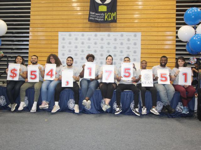Kean University students proudly display the fundraising tally for the Kean Dance Marathon.