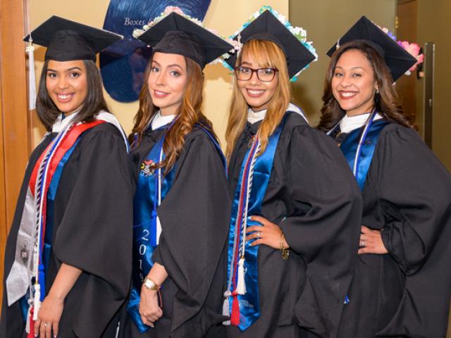 Four women graduating from Kean University's Nathan Weiss Graduate Program pose together.