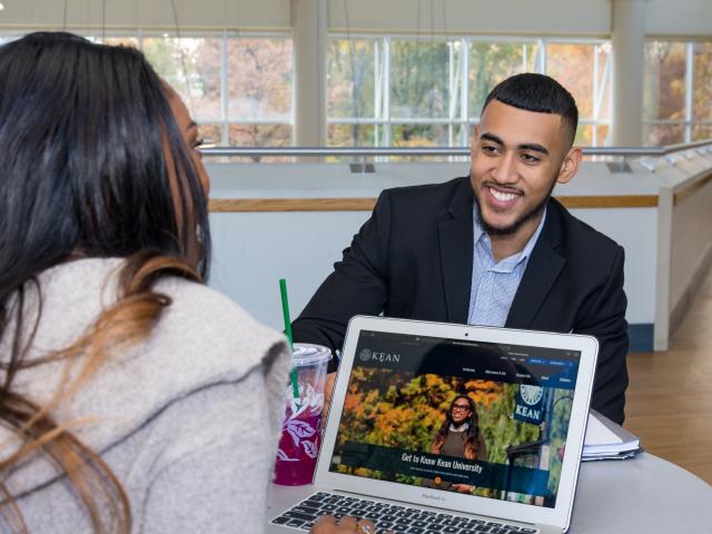 Two students chat in a campus lounge