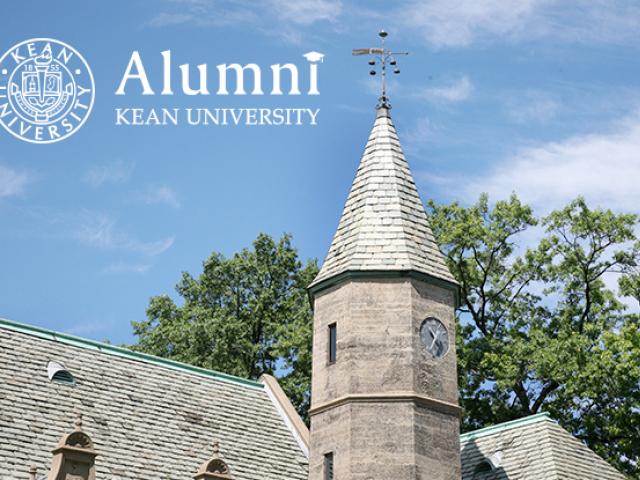 The roof of Kean Hall with the logo for Kean the Alumni Engagement office against a blue sky.