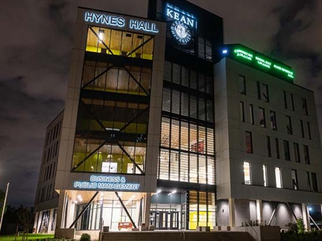 Kean's Hynes Hall at Night, with an illuminated ticker running across one side.