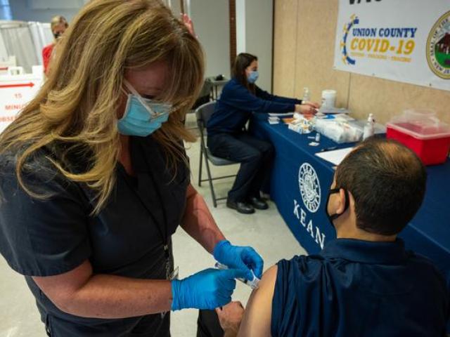 A nurse gives a vaccine to a male patient at Kean University's Union County vaccination site.
