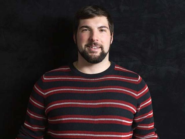 Charles Raimondo in a black, red and white striped shirt.