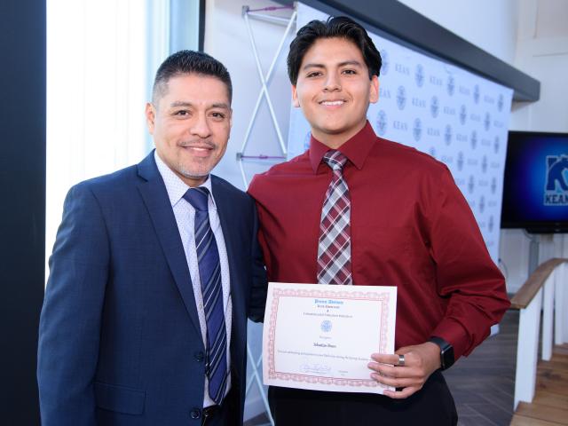 A student poses with award at project Adelante event