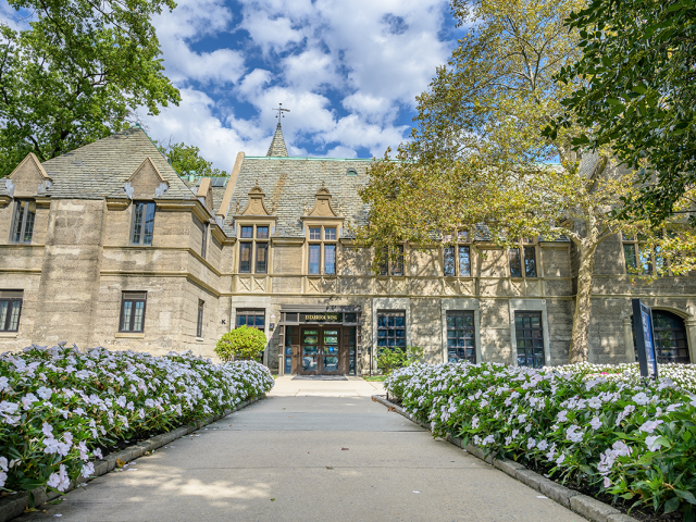 Kean Hall at Kean University, with a path decorated with flowers leading to it.