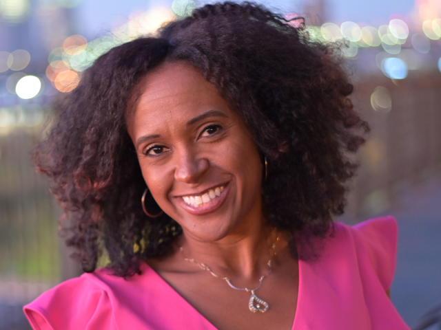 Saran Nurse, Ph.D., a Black woman wearing a pink blouse, smiles.