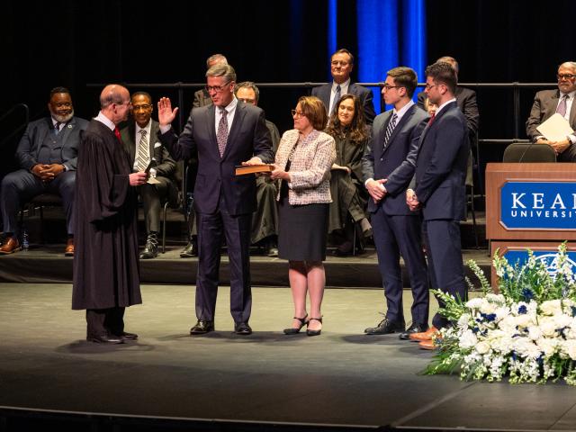 Justice Fasciale takes the oath of office on Wilkins Theatre's stage, surrounded by his wife and sons.