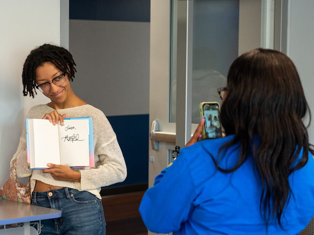 A student shows off a book, autographed by author George M. Johnson, at the 2022 Common Read.