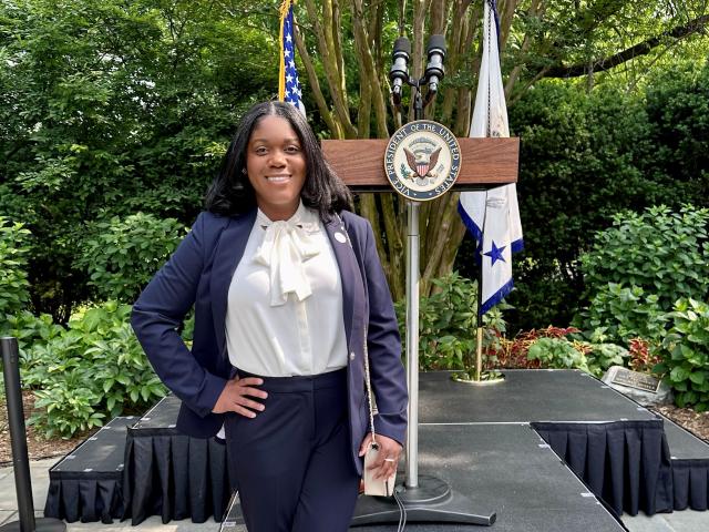 Kean alumna Nekeisha Blandin poses in front of the podium at the vice president's house, during the Dia De Las Madres event