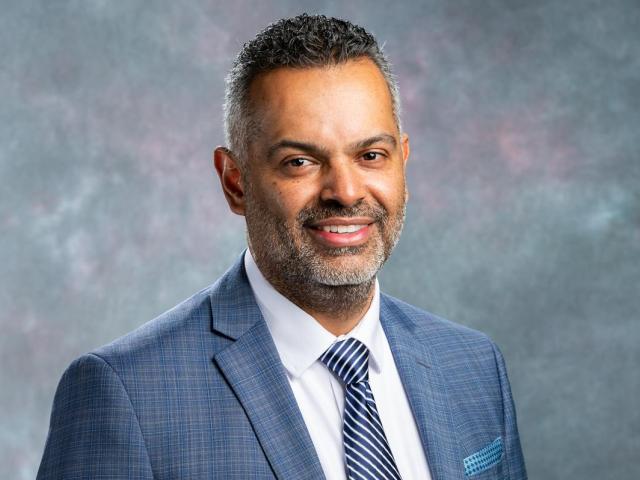 Marvin Adames, in a blue suit, white shirt and striped blue tie