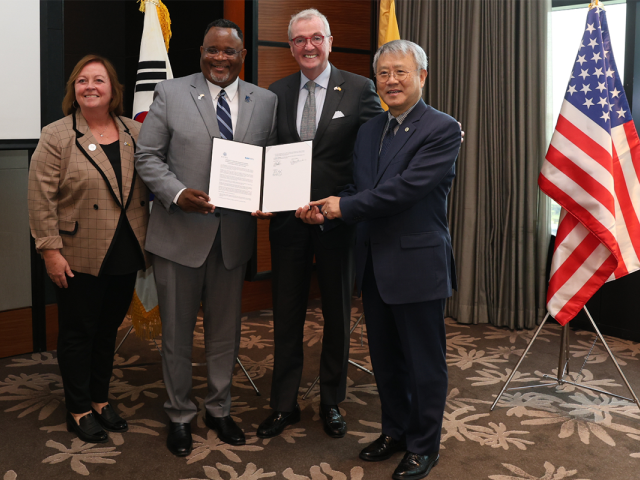 Kean President Repollet and Chief of Staff Audrey Kelly, with Governor Murphy hold signed agreement.