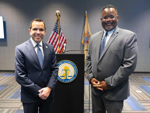 The attorney general and the Kean president stand at a podium