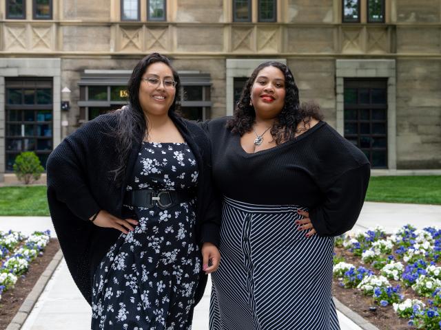 The smiling mother and daughter pose in front of Kean Hall.