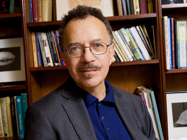 Playwright Benjamin V. Marshall poses in front of a bookshelf.