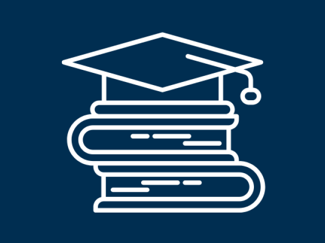 A stack of books with a graduation cap on top 