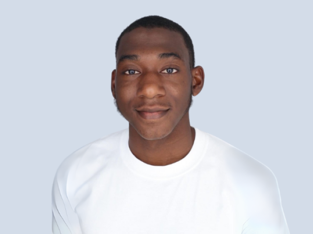Smiling Black male with short hair wearing a white shirt