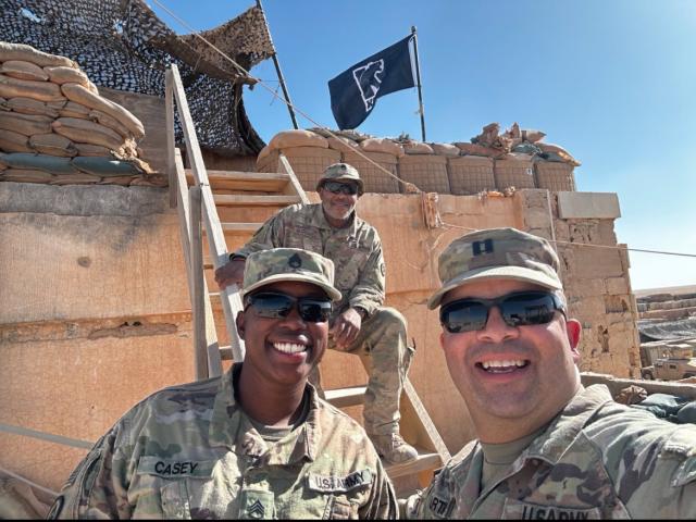 Three NJ National Guard members, all Kean alumni, fly a Kean flag at their post in Syria