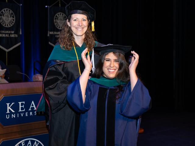 Kean doctoral candidate adjusts her cap at the Doctoral Hooding Ceremony