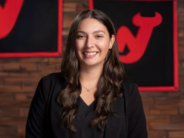 Christina Chiarella poses in front of the NJ Devils logo
