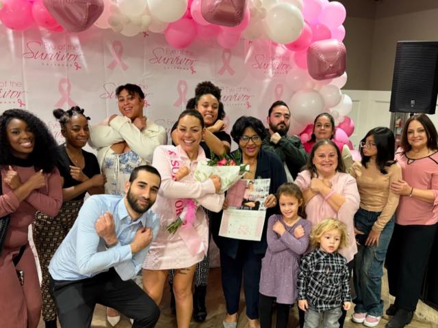 Large group of people surrounded by pink and white balloons