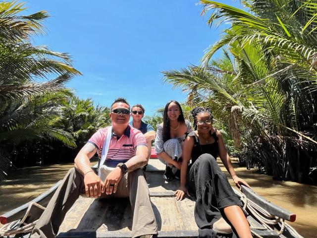 Two men and two women on a boat on a beach