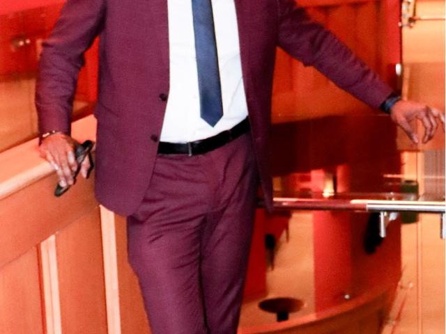 man in burgundy suit and black tie